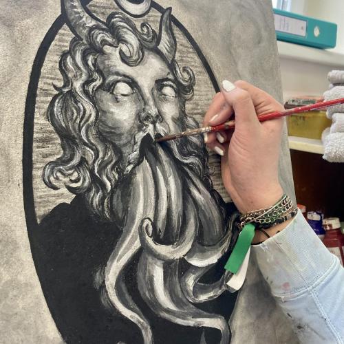Schülerin malt einen Teufel in Freskotechnik